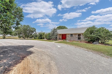 View of front of home with brick, a front yard, and driveway