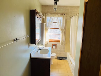 Full bathroom featuring vanity, light tile patterned floors, shower / bath combination with curtain, and tile walls