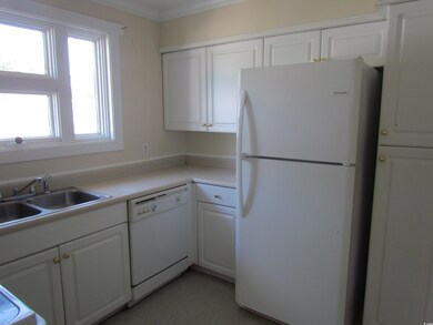 Kitchen with white cabinets, sink, white appliance