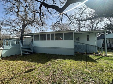 Back of house featuring a wooden deck, a lawn, an