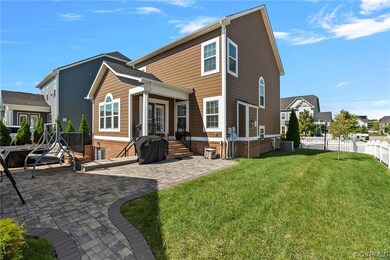 Rear view of property with a lawn and a patio