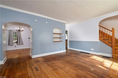 Wood floored spare room with built in shelves and 