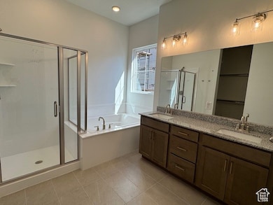 Full bath with a garden tub, a shower stall, double vanity, light tile patterned flooring, and recessed lighting
