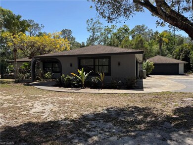 Rear view of property with stucco siding, an outbu
