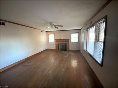 Living room with triple window and the second fireplace.