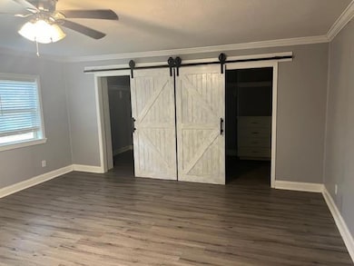 Unfurnished bedroom with a barn door, a closet, ce