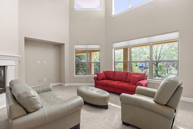 Living area featuring carpet, a towering ceiling,