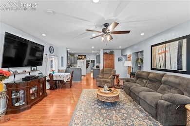 Living area with light wood-style flooring, recessed lighting, and a ceiling fan