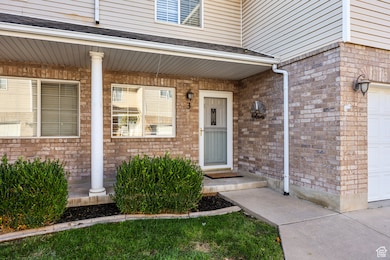 Doorway to property featuring brick siding, a porch, and roof with shingles
