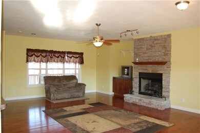 Large living room with stone fireplace. Fireplace can be woodburner or used with gas logs.  No tank.