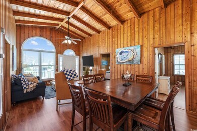 Dining room featuring beamed ceiling, wooden walls