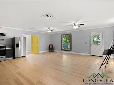Unfurnished living room featuring a ceiling fan, plenty of natural light, crown molding, and light wood-type flooring