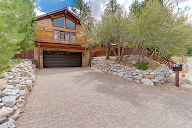 View of front of property with decorative driveway, a balcony, and a garage