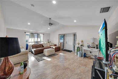 Living room with vaulted ceiling, ceiling fan, and