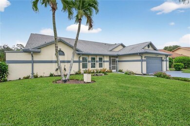 View of front of home featuring a front lawn, stucco siding, an attached garage, and driveway