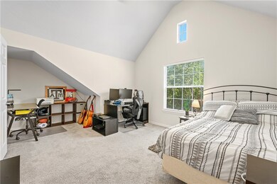 Carpeted bedroom with baseboards and high vaulted