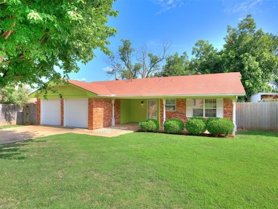 Single story home with a garage, driveway, and brick siding