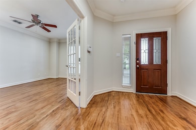 Entryway featuring crown molding, light wood finished floors, and a ceiling fan