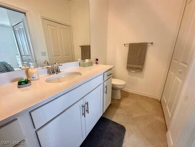 Ensuite bathroom featuring baseboards, toilet, ensuite bathroom, and vanity