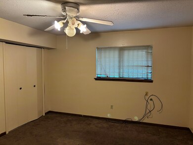 Unfurnished bedroom featuring dark carpet, a close