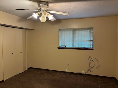 Unfurnished bedroom featuring dark carpet, a close