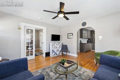 Living room with arched walkway and view into the kitchen