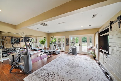 Gym with french doors, recessed lighting, healthy