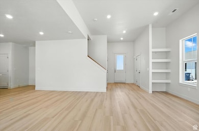 Unfurnished living room with light wood finished floors and recessed lighting