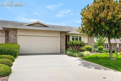 Single story home featuring brick siding, an attached garage, driveway, a front lawn, and a shingled roof