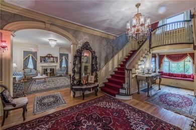 Center hall foyer with grand staircase and firepla