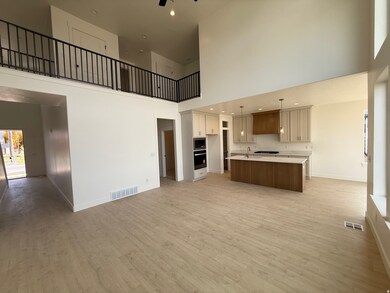 Unfurnished living room featuring a high ceiling, light wood finished floors, recessed lighting, and a ceiling fan