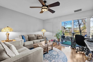 Living room featuring ceiling fan and light hardwo
