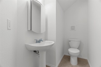 Bathroom featuring lofted ceiling, toilet, and til