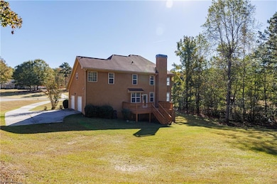 Back of property with stairs, a lawn, a chimney, and a deck