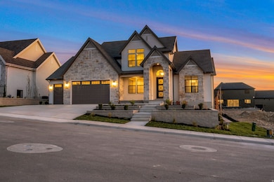 French country style house with stone siding, driveway, and a garage