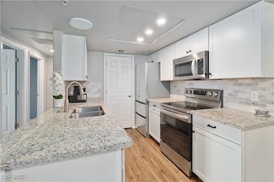 Alternate angle of the Kitchen, showcasing the granite countertops and the tile backsplash. Also pictured is the modern recessed ceiling light fixtures.