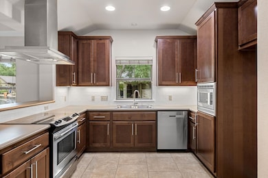 Updated kitchen with swanky vent hood, under-cabinet lighting, a window over the sink and pull-out shelving inside the cabinets.
