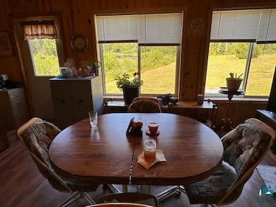 Dining space featuring healthy amount of natural light, wood finished floors, and wooden walls