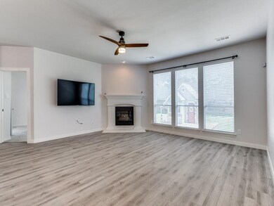 Unfurnished living room featuring ceiling fan and 