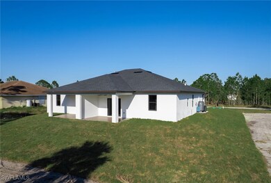 Back of property with a yard and stucco siding