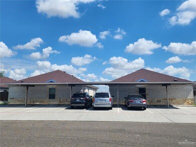 View of side of property with covered and uncovered parking and brick siding