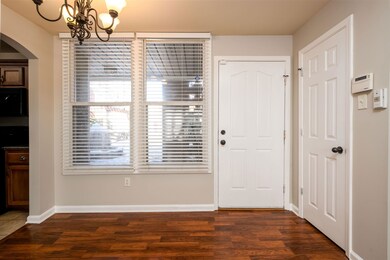 Foyer entrance with an inviting chandelier and dar