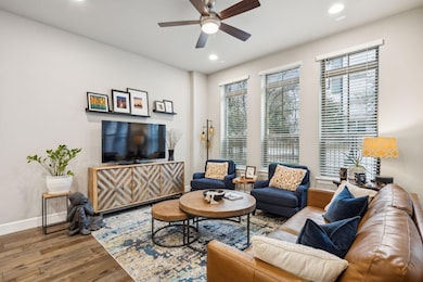 Living room with ceiling fan, baseboards, wood fin