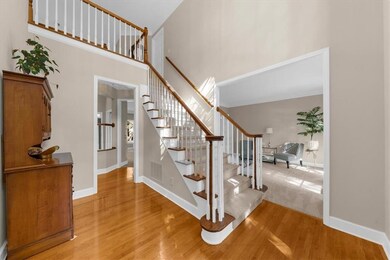 Stairway with wood finished floors and a towering ceiling