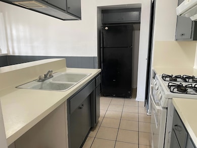 Kitchen featuring a sink, light tile patterned fl