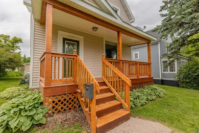 Entrance to property featuring covered porch and a lawn