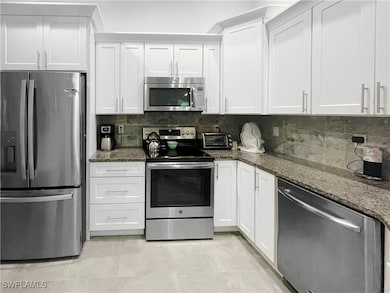 Kitchen with stainless steel appliances, dark ston