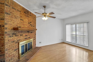 Unfurnished living room featuring a brick fireplac
