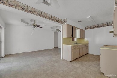 Kitchen featuring ceiling fan, sink, and light tile floors
