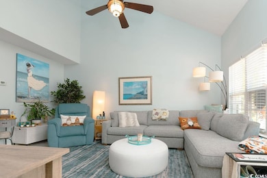 Living room with ceiling fan and high vaulted ceil
